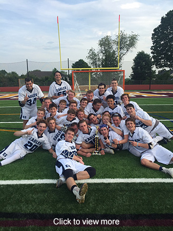 Boys lacrosse team members pose on a field with an award