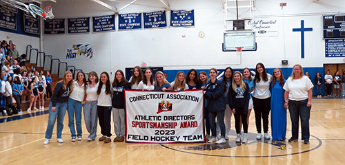 Field Hockey team holding banner