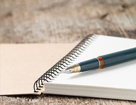 Pen sits on top of a notebook