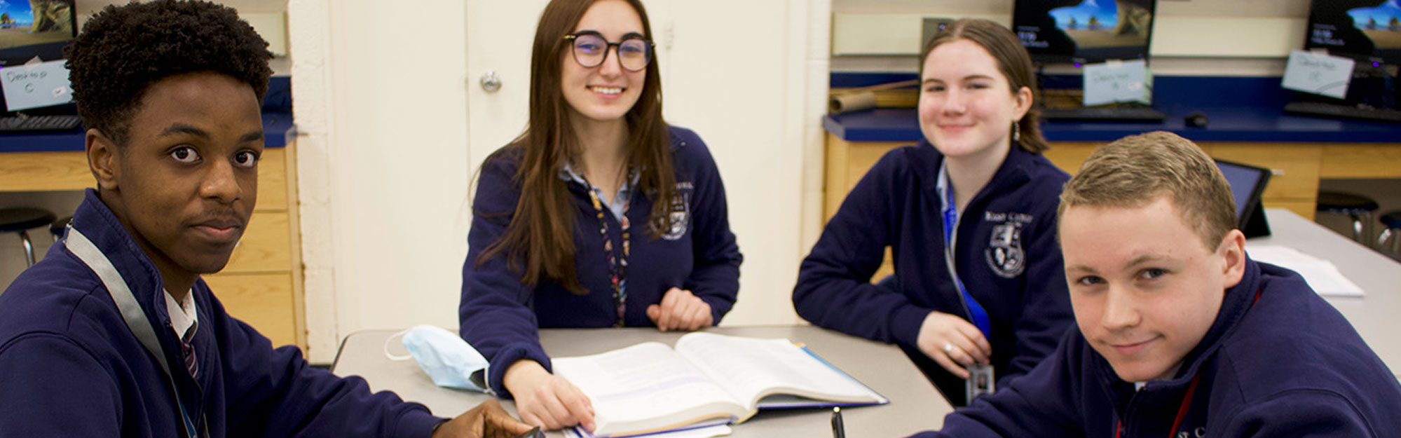 Four happy students sitting at a table together