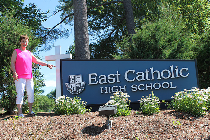 Sr. Peggy in front of East Catholic High School sign
